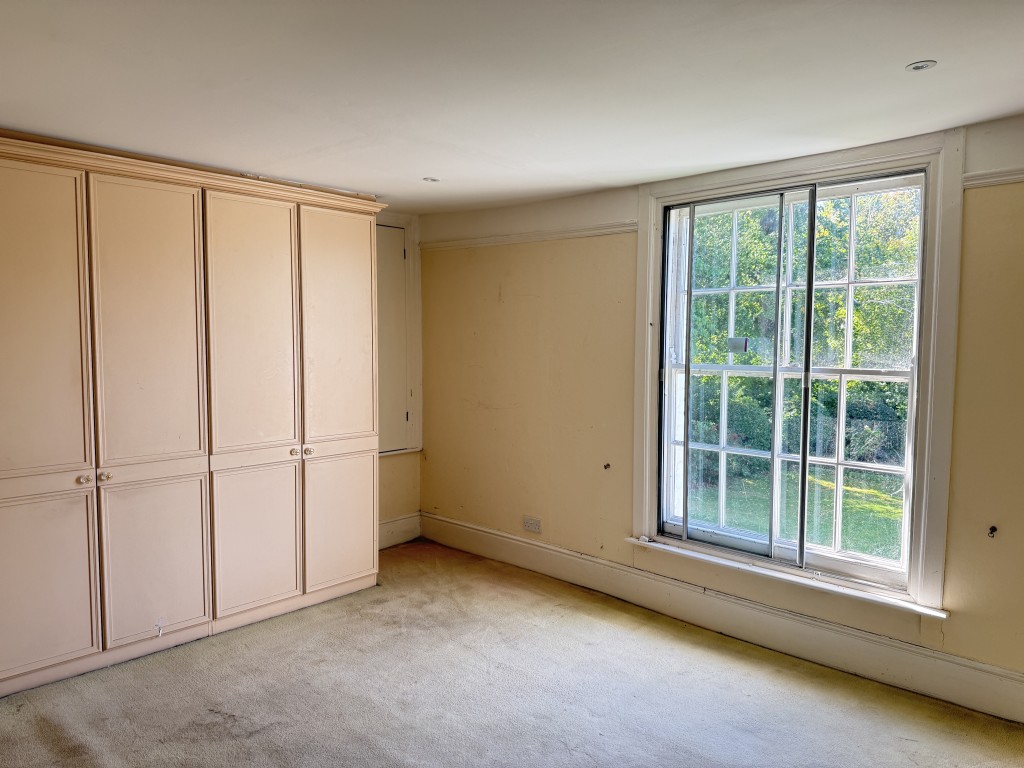 Lot: 192 - TWO-BEDROOM FLAT IN NEED OF IMPROVEMENT - Bedroom showing view and wardrobes